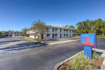 a sign in front of a building with a parking lot at Studio 6 Extended Stay - Kissimmee, FL - Orlando in Orlando