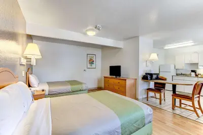 a hotel room with two beds and a kitchen at Studio 6 Extended Stay - Kissimmee, FL - Orlando in Orlando