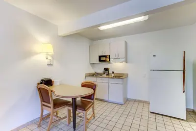 a kitchen with a table and chairs and a refrigerator at Studio 6 Extended Stay - Kissimmee, FL - Orlando in Orlando