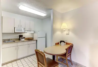 a small kitchen with a table and chairs in a room at Studio 6 Extended Stay - Kissimmee, FL - Orlando in Orlando