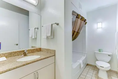a white bathroom with a toilet and a sink at Studio 6 Extended Stay - Kissimmee, FL - Orlando in Orlando