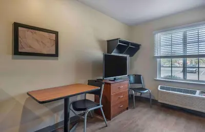 a room with a desk with a computer and two chairs at Extended Stay America Select Suites - Orlando - Sanford - Airport in Sanford