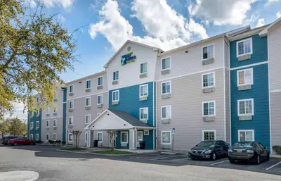 a large building with cars parked in a parking lot at Extended Stay America Select Suites - Orlando - Sanford - Airport in Sanford