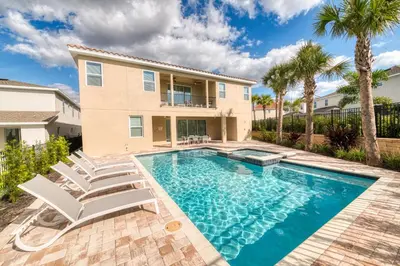 a swimming pool with chairs and a house at Fabulous Home With Air Hockey, Media Room And Waterpark & Resort Access Near Disney At Encore Resorts Reunion - 290Fl in Kissimmee