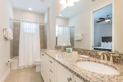 a bathroom with a sink and a toilet and a mirror at Welcoming Home With Air Hockey Table And Waterpark & Resort Access Near Disney At Encore Resorts Reunion - 321Bu in Kissimmee