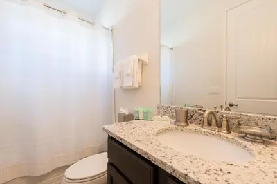 a bathroom with a sink and a toilet and a mirror at Lovely Home With Private Pool And Air Hockey Table Near Disney With Waterpark & Resort Access At Encore Resort - 7467Mr in Kissimmee