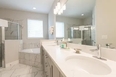a white bathroom with two sinks and a tub at Remarkable Home Near Disney With Theater & Themed Rooms With Waterpark & Resort Access At Encore Resort - 7660Ff in Kissimmee