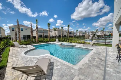 a swimming pool with chairs and a villa at Cozy Home With Private Pool, Air Hockey Table Near Disney With Waterpark & Resort Access At Encore Resort - 7702Gr in Kissimmee