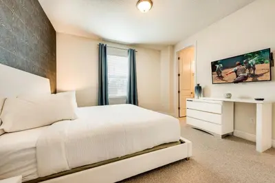 a bedroom with a white bed and a desk at Chic Home With Mini Soccer Field, Golf Near Disney With Waterpark & Resort Access At Encore Resort - 7715Ff in Kissimmee