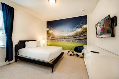 a bedroom with a bed and a baseball game on the wall at Chic Home With Mini Soccer Field, Golf Near Disney With Waterpark & Resort Access At Encore Resort - 7715Ff in Kissimmee