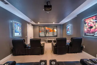 a movie room with black chairs and a painting on the wall at Spectacular Home With Theater, Theme Rooms Near Disney With Waterpark & Resort Access At Encore Resort - 7734Gr in Kissimmee
