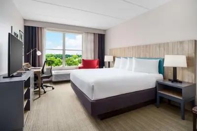 a hotel room with a large bed and a desk at Country Inn & Suites by Radisson, Orlando Airport, FL in Orlando