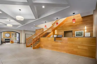 a large lobby with a staircase with wooden walls at Country Inn & Suites by Radisson, Orlando Airport, FL in Orlando