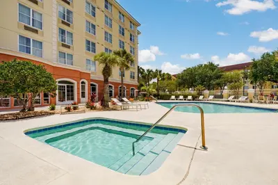 a swimming pool in front of a building at Country Inn & Suites by Radisson, Orlando Airport, FL in Orlando