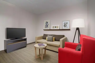 a living room with a couch and a tv at Country Inn & Suites by Radisson, Orlando Airport, FL in Orlando
