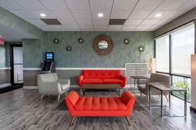 a waiting room with two red couches and chairs at Ramada by Wyndham Altamonte Springs Near I-4 in Orlando
