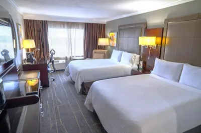 a hotel room with two beds and a flat screen tv at Holiday Inn Orlando East-UCF Area by IHG in Orlando