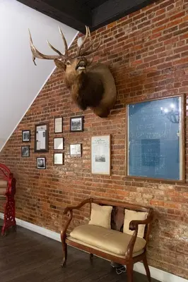 a wall with a moose head hanging on a brick wall at Hunter Arms Hotel in Saint Cloud