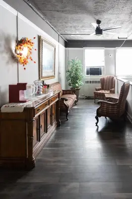 a living room with a table and chairs and a couch at Hunter Arms Hotel in Saint Cloud