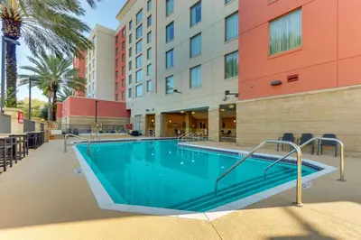 a swimming pool in front of a building at Drury Inn & Suites Orlando near Universal Orlando Resort in Orlando