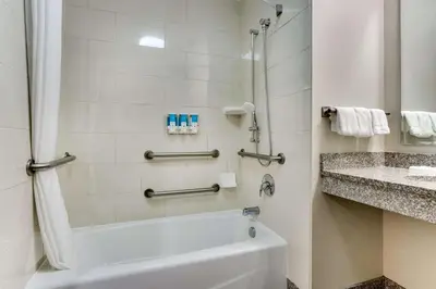 a bathroom with a white tub and a sink at Drury Inn & Suites Orlando near Universal Orlando Resort in Orlando