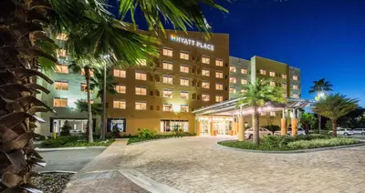 a hotel building with a palm tree in front of it at Hyatt Place Orlando/Lake Buena Vista in Orlando