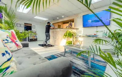 a man standing on a counter in a room with plants at Sunshine Inn in Kissimmee