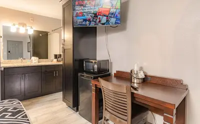 a small kitchen with a desk and a microwave at Sunshine Inn in Kissimmee