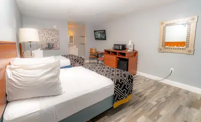 a hotel room with a bed and a desk at Sunshine Inn in Kissimmee