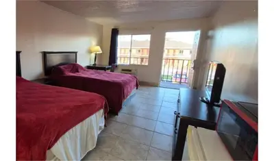 a hotel room with two beds and a balcony at Central Motel Kissimmee Near Disney World in Kissimmee