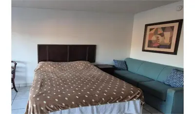 a bed and a couch in a room at Central Motel Kissimmee Near Disney World in Kissimmee
