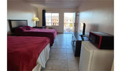 a hotel room with two beds and a television at Central Motel Kissimmee Near Disney World in Kissimmee