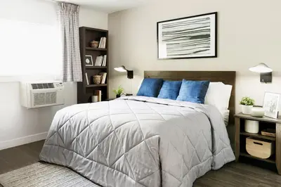 a bedroom with a large bed with blue pillows at InTown Suites Extended Stay Orlando FL - Universal in Orlando