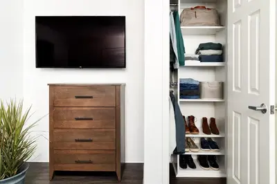 a closet with a television and a dresser with shoes at InTown Suites Extended Stay Orlando FL - Universal in Orlando