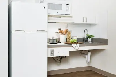 a kitchen with a sink and a white refrigerator at InTown Suites Extended Stay Orlando FL - South in Orlando