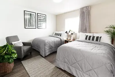 a bedroom with two beds and a chair at InTown Suites Extended Stay Orlando FL - South in Orlando