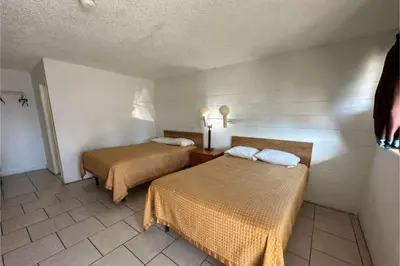 a room with two beds in a room at Arrow Motel by OYO Near Downtown in Orlando