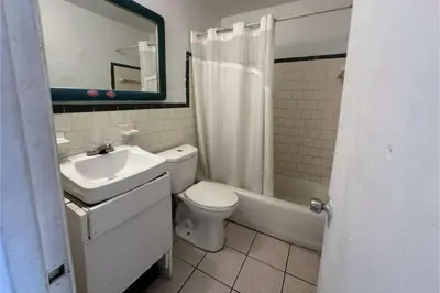 a bathroom with a sink and a toilet and a tub at Arrow Motel by OYO Near Downtown in Orlando