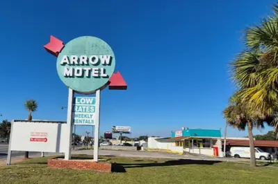 a sign for an arrow motel in a parking lot at Arrow Motel by OYO Near Downtown in Orlando