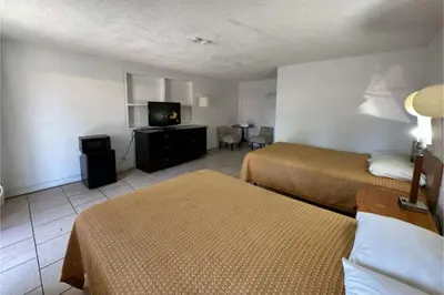 a hotel room with two beds and a flat screen tv at Arrow Motel by OYO Near Downtown in Orlando