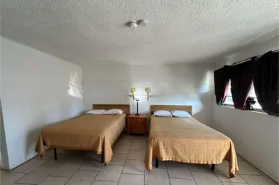 a room with two beds in a room at Arrow Motel by OYO Near Downtown in Orlando