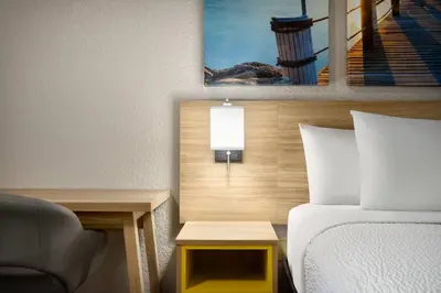 a hotel room with a bed and a chair at Days Inn by Wyndham Apopka/Orlando in Orlando