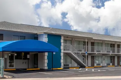 a building with a blue awning in a parking lot at Days Inn by Wyndham Apopka/Orlando in Orlando