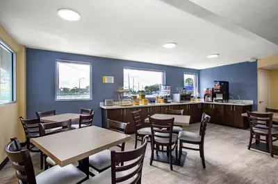 a restaurant with tables and chairs and a counter at Days Inn by Wyndham Apopka/Orlando in Orlando