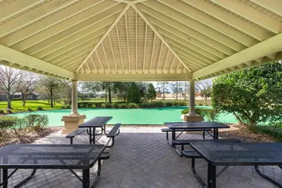 a pavilion with picnic tables and benches on a patio at Fantastic Condo - 2 Miles from Disney Pool View Windsor Hills in Orlando