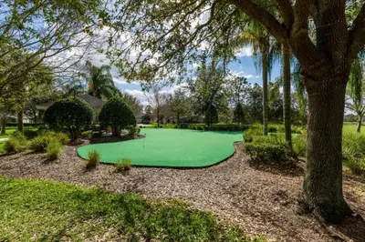 a green golf course in a park with a tree at Fantastic Condo - 2 Miles from Disney Pool View Windsor Hills in Orlando
