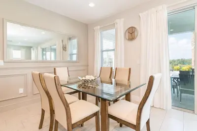 a dining room with a glass table and chairs at Charming Home With Private Pool Near Disney With Water Park & Resort Access At Encore Resort - 7489Mr in Kissimmee
