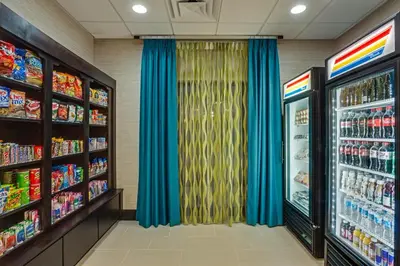 a grocery store aisle with blue curtains and soda machines at Holiday Inn Express Hotel & Suites Orlando East-UCF Area by IHG in Orlando