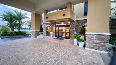 a large house with a stone walkway in front of it at Holiday Inn Express Hotel & Suites Orlando East-UCF Area by IHG in Orlando