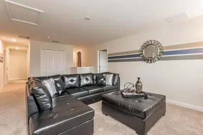 a living room with black leather furniture and a mirror at Enchanting Escape Private Pool SPA Games Room in Orlando